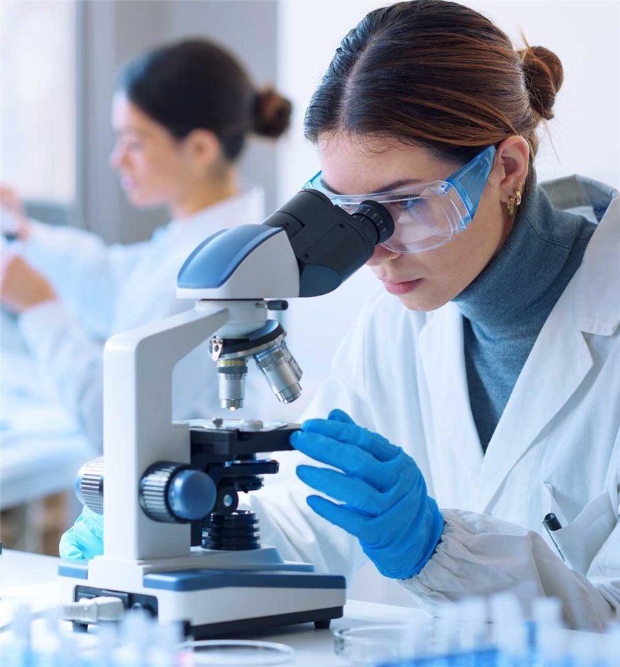 Scientist examining samples under a microscope in a laboratory