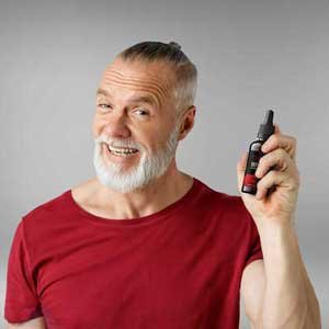 Man in his fifties holding a bottle of Sugar Defender drops